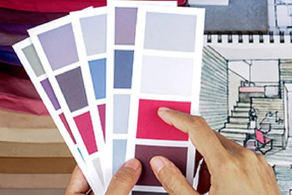 Person wählt Farbe von Farbkarte